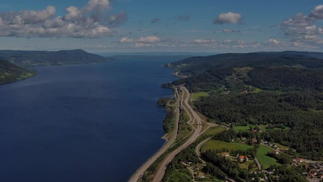 Minnesund highway in southern Norway - Aerial Drone scenes - flying north flanked by Norways biggest lake called Glomma to the left - High altitude