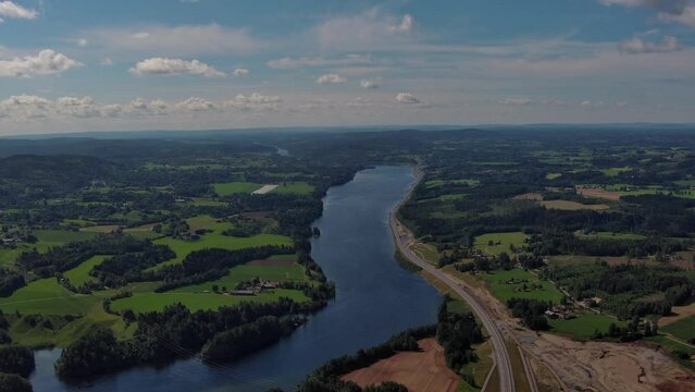 Landscape scene of fields and forest wit he the Glomma River in the middle of the frame from Minnesund in southern Norway - Aerial Drone scene