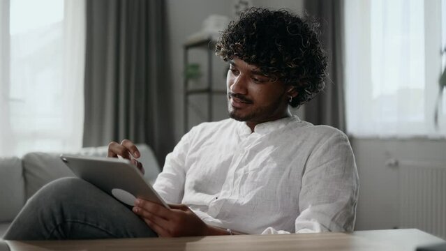 Portrait of handsome creative young man student digital illustrator thinks questioningly create idea for new drawing at desk next to tablet at home workplace
