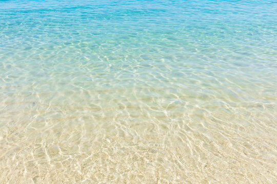 Ripples of the crystal-clear sea waters near the sand of Praia do Dentista, in Ilha Grande, RJ, Brazil.