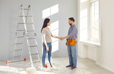 House owner hires a repairman while doing renovations at home. Young woman and the repair service...