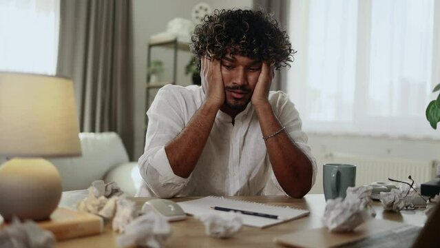 Portrait of exhausted tired young indian man student or freelancer with failed ideas while take break at home workplace Tired male with creative block or lack of inspiration indoors	