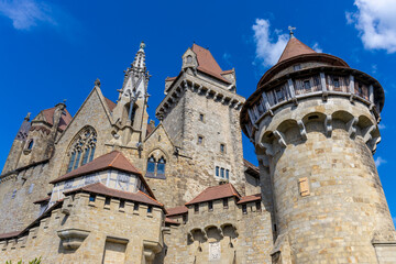 Castle landmark under blue sky. Medieval castle in Austria. Ancient historical sights around Vienna. Castle Kreuzenstein old building from outside