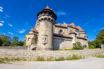 Castle landmark under blue sky. Medieval castle in Austria. Ancient historical sights around Vienna. Castle Kreuzenstein old building from outside