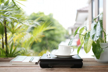 Vintage teapot and tea cup on black wooden tray on wooden table outdoor