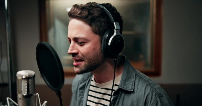 Recording, music and man with singing in studio for entertainment, production and song on album. Musician, headphones and artist with microphone for audio media, sound and broadcast at record label
