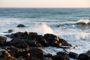 View of the surf on the rocky seaside after sunrise