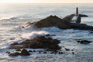 Naklejka premium View of the surf on the rocky seaside after sunrise