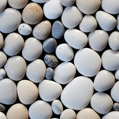 A pattern of smooth, round pebbles with varying shades and shapes - Seamless tile