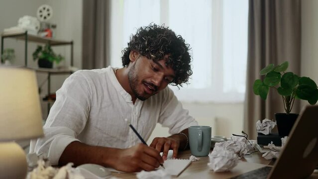 Tired exhausted stressed young indian man student preparing for exams and looking at scope of work with sad face at home workplace Overwork education concept

