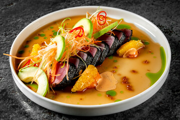 tuna tataki with vegetables and sauce on white plate