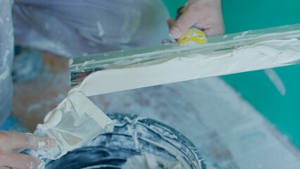 Worker Preparing Putty for Wall Application with Trowel