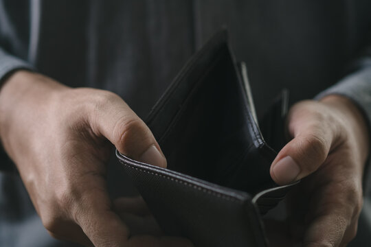 Businessman hand holding An Empty wallet. feeling stressed without cash, having financial problems, suffering from lack of money, bankruptcy concept.
