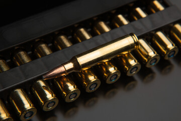 Bullet isolated on black background with reflexion. Rifle bullets close-up on black back....