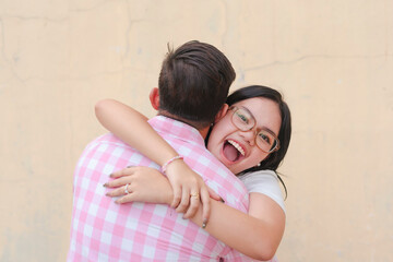A young asian woman hugs her dad. Reconciling with her father. Outdoor urban scene.