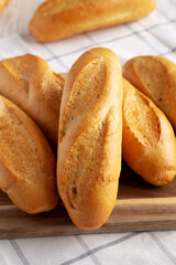 Homemade Mini baguettes on a wooden board, side view. Close-up.