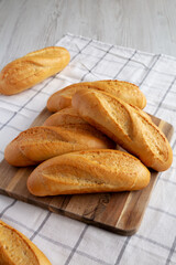 Homemade Mini baguettes on a wooden board, side view. Close-up.