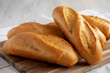 Homemade Mini baguettes on a wooden board, side view. Close-up.