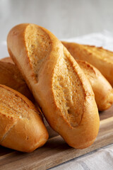 Homemade Mini baguettes on a wooden board, side view. Close-up.