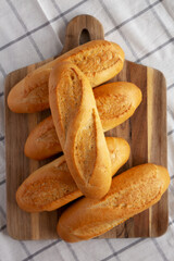 Homemade Mini baguettes on a wooden board, top view. Flat lay, overhead, from above.