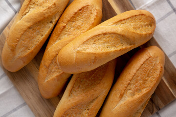 Homemade Mini baguettes on a wooden board, top view. Flat lay, overhead, from above.