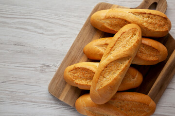 Homemade Mini baguettes on a wooden board, top view. Flat lay, overhead, from above. Copy space.