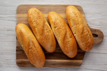 Homemade Mini baguettes on a wooden board, top view. Flat lay, overhead, from above.