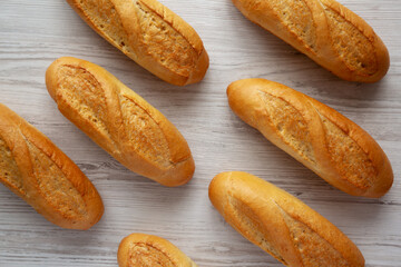 Homemade Mini baguettes on a wooden board, top view. Flat lay, overhead, from above.