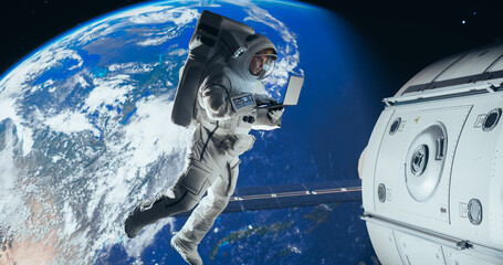 Male Astronaut Using Laptop to Wirelessly Connect to a Satellite. Spaceman Working on Device in...