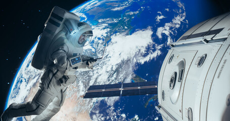 Young Astronaut Floating in Space in Zero Gravity. Spaceman Using Laptop Computer in Open Space Outside an Orbiting Spacecraft, Browsing Instruction Manuals for Maintenance Work on a Satellite © Gorodenkoff