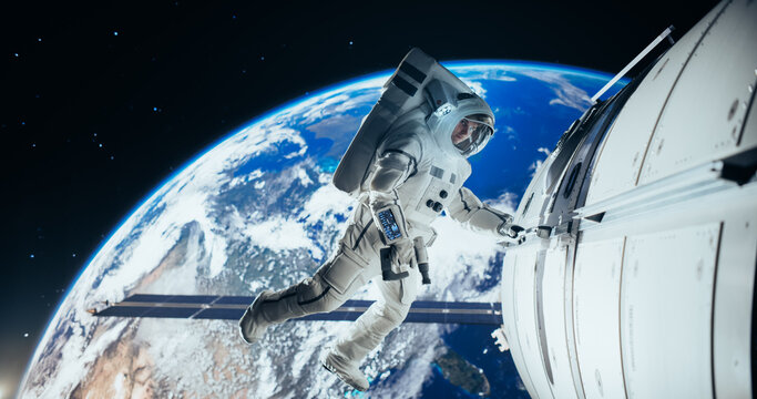 Astronaut on an Extravehicular Mission in Outer Space Far From Planet Earth. Brave Man Holding by the Handle, Slowly Moving Outside the Space Station During a Service Procedure in Zero Gravity