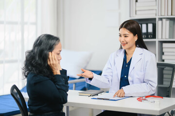 A woman is sitting at a desk with a doctor