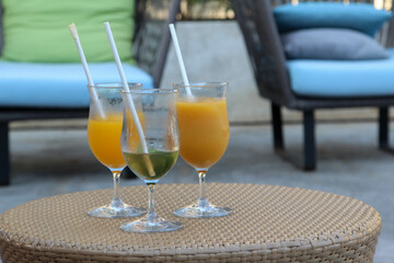 Iced orange juice and iced tea on a rattan tray