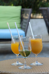 Iced orange juice and iced tea on a rattan tray