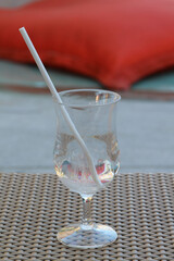 An empty glass on a rattan tray