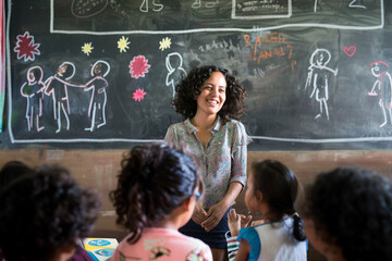 Empowering Education: A Young Teacher's Impact in a Disadvantaged Community smiling near the...