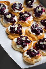 Homemade puff pastry cakes with cottage cheese and cherry jam