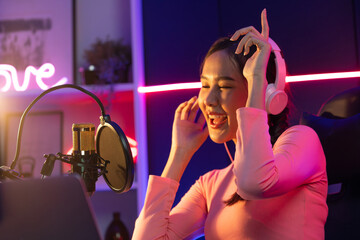 Host channel of young beautiful Asian broadcaster listening the music on social media with...