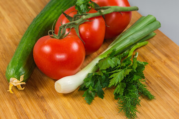 Various fresh vegetables and herbs on a wooden cutting board