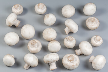 Fresh raw whole button mushrooms on a gray surface