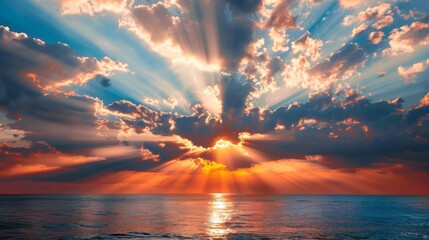 Beams of light breaking through the clouds during a breathtaking sunset over the ocean