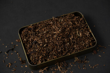 fine tobacco in a gold iron box on a black table
