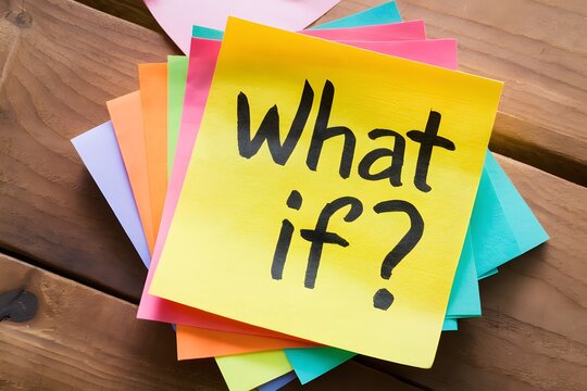 Bright yellow sticky note with WHAT IF? in black ink on wooden surface