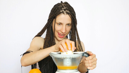 A young braids girl making orange juice with concentration