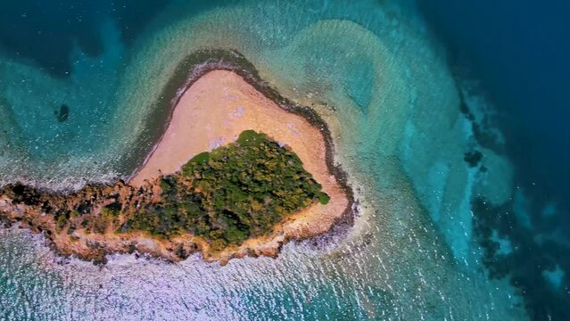 Aerial view of very small island in Gocek Mugla TURKEY blue and turquoise crystal clear water and plants on the island camera tilt 90 degree down and moves left