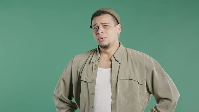 Frightened man on green backdrop. Phobia, trouble, panic concept. Scary surprise