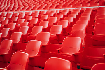 Naklejka premium Football stadium with empty seats. Outstanding empty red plastic chair at soccer arena. Row of unoccupied bench at sports stadium