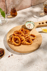 Tempting Tempura Squid Rings with Tartar Sauce in Sunlit Still Life Setting