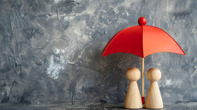 Wooden toy figures under a red umbrella against grey background, concepts of family protection, security, and life insurance. The minimalist setup conveys a sense of care and safety