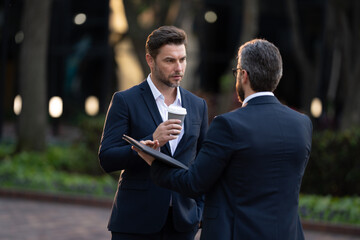 two businessmen in suits on the street talking about a new deal Emotional male businessman talks to...
